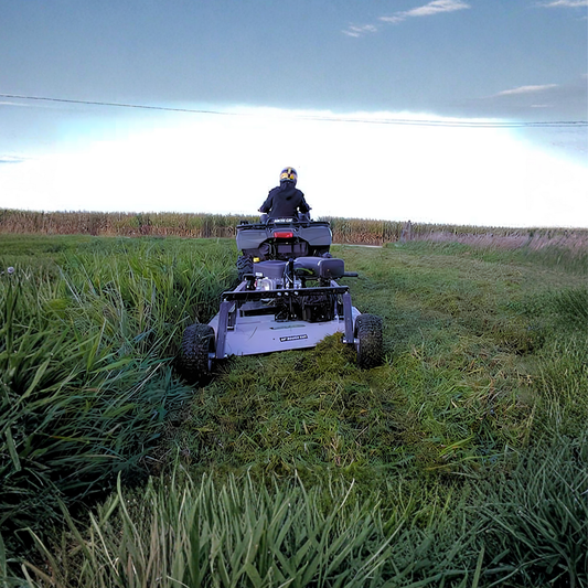 Person operating a Kunz Rough Cut Mower AcrEase in a grassy field